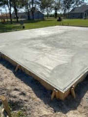 A large concrete slab is sitting on top of a dirt field.