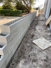 A brick wall is being built on the side of a house.