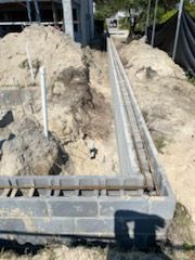 A brick wall is being built next to a pile of dirt.