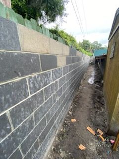 A brick wall is being built next to a dirt path.