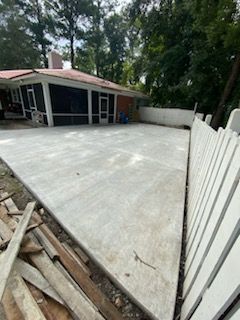 A concrete driveway is being built in front of a house.