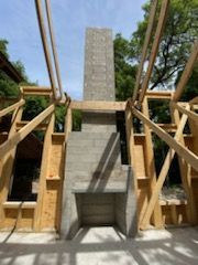 A fireplace is being built in a house under construction.