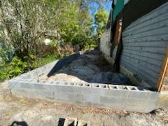 A brick wall is being built in front of a garage.