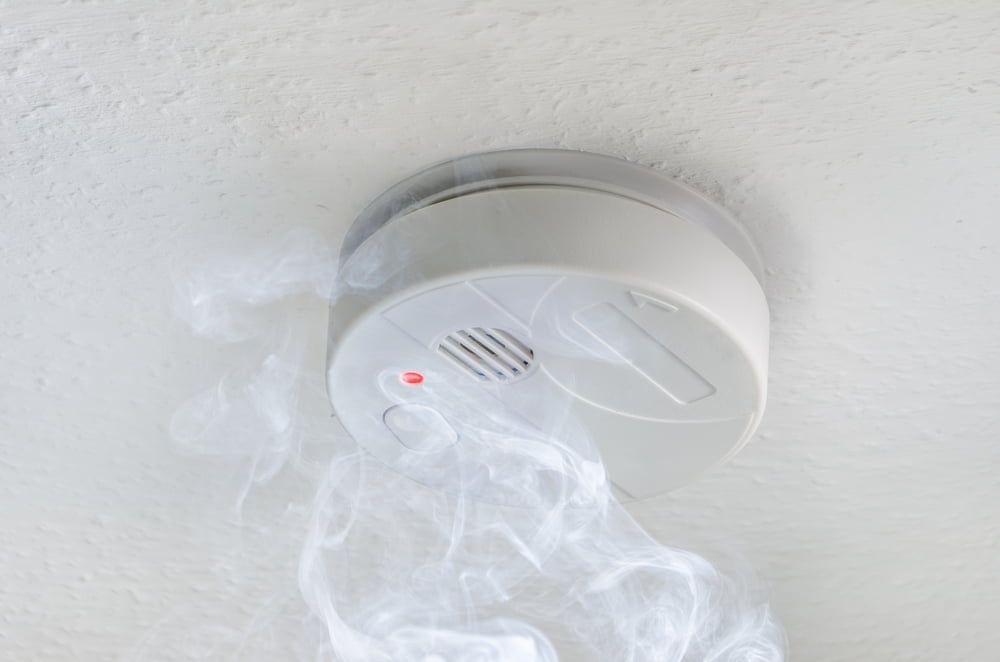 A Smoke Detector on The Ceiling with Smoke Coming out Of It — Hantis Electrical Solutions in North Nowra, NSW