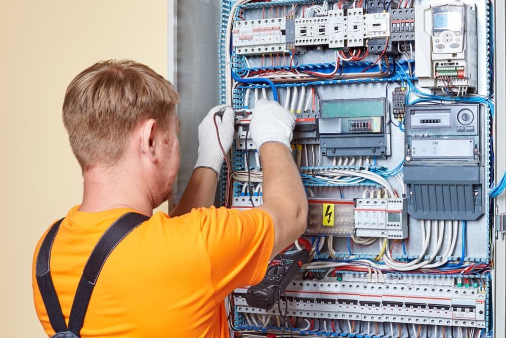 An Electrician Is Working on An Electrical Panel — Hantis Electrical Solutions in Shellharbour, NSW