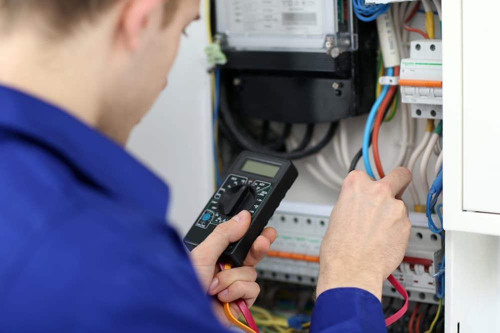 An Electrician Is Using a Multimeter to Check a Meter — Hantis Electrical Solutions in Kiama, NSW