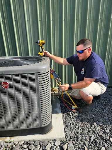 A man is working on an air conditioner outside of a building.