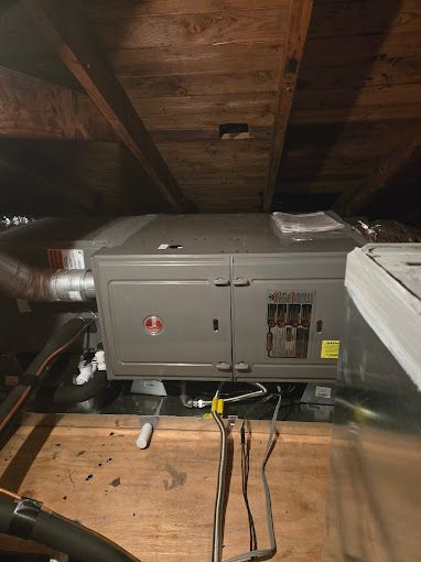 A large box is sitting in the attic of a house.