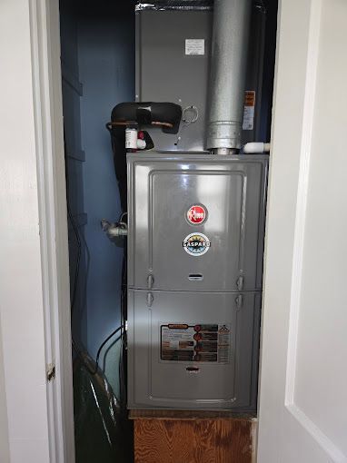 An air conditioner is sitting in a closet next to a door.