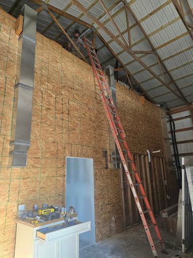 A man is standing on a ladder in a building.