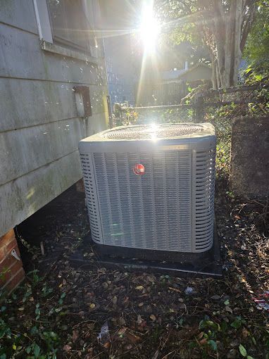 A large air conditioner is sitting on the side of a house.