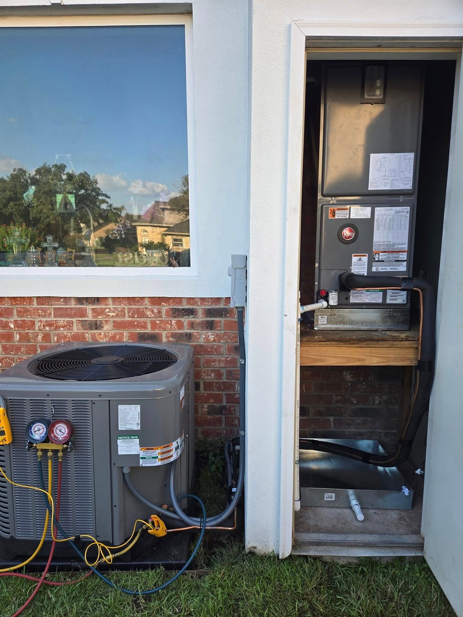 An air conditioner is being installed on the side of a house.