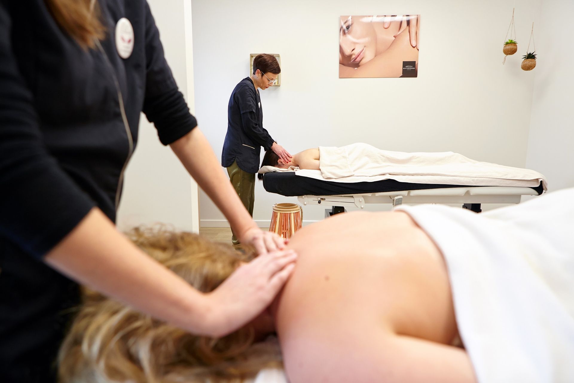 Deux femmes donnent un massage à une femme dans un spa.
