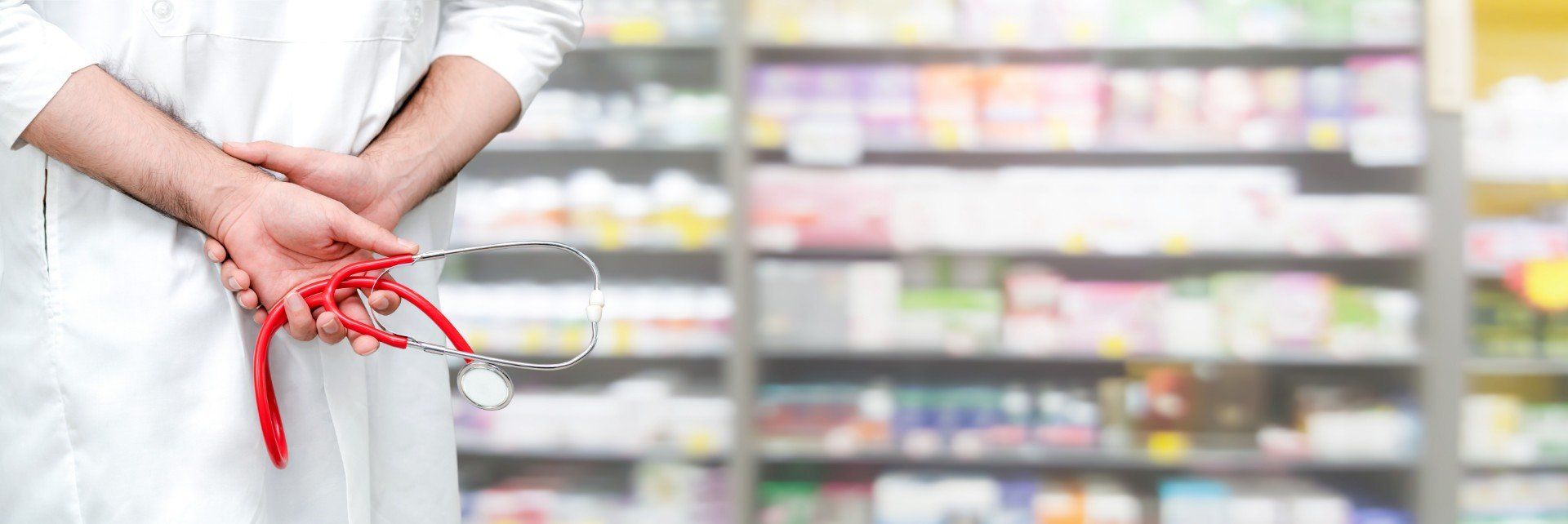 Farmacista con sullo sfondo alcuni medicinali in esposizione