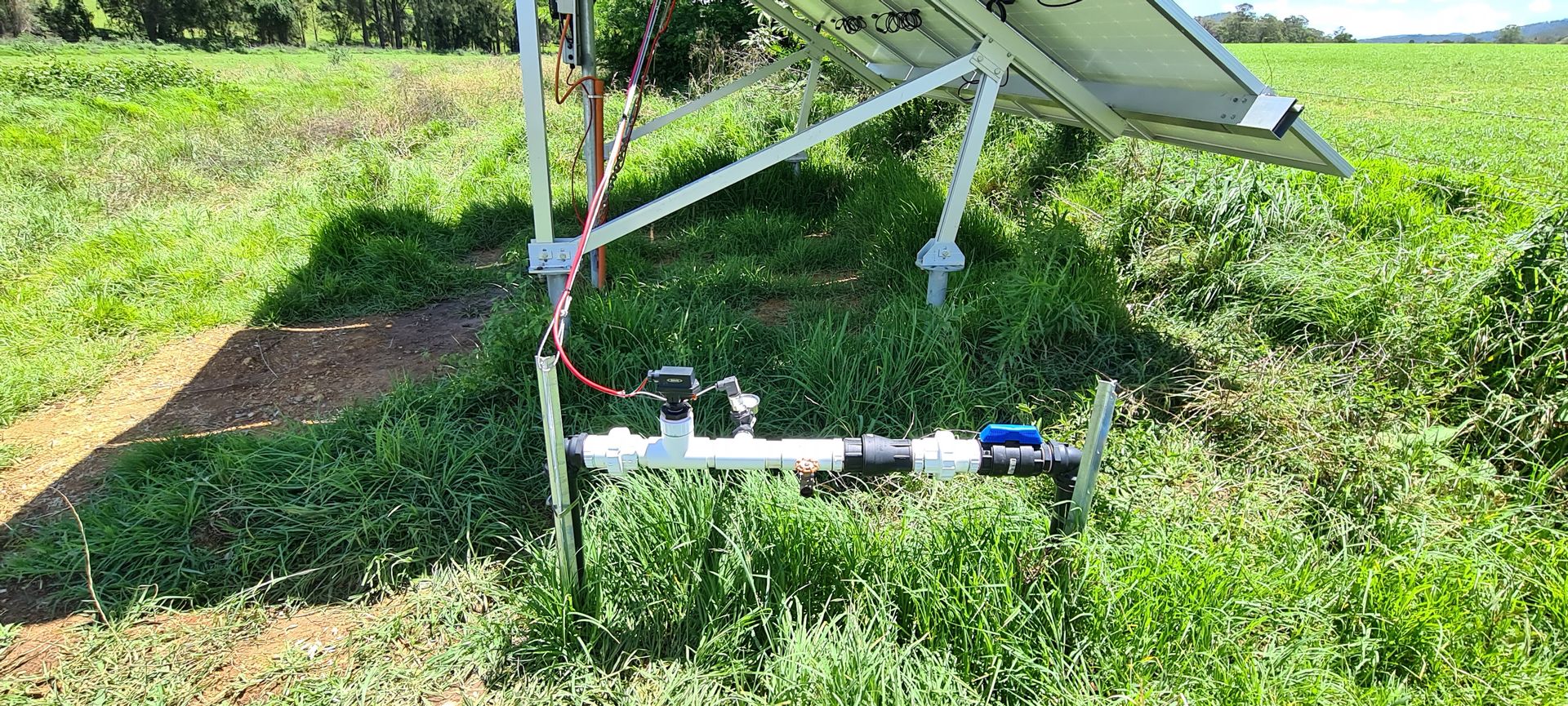 A solar panel is sitting in the middle of a grassy field.— Midcoast Irrigation & Horticultural Supplies In Wauchope, NSW