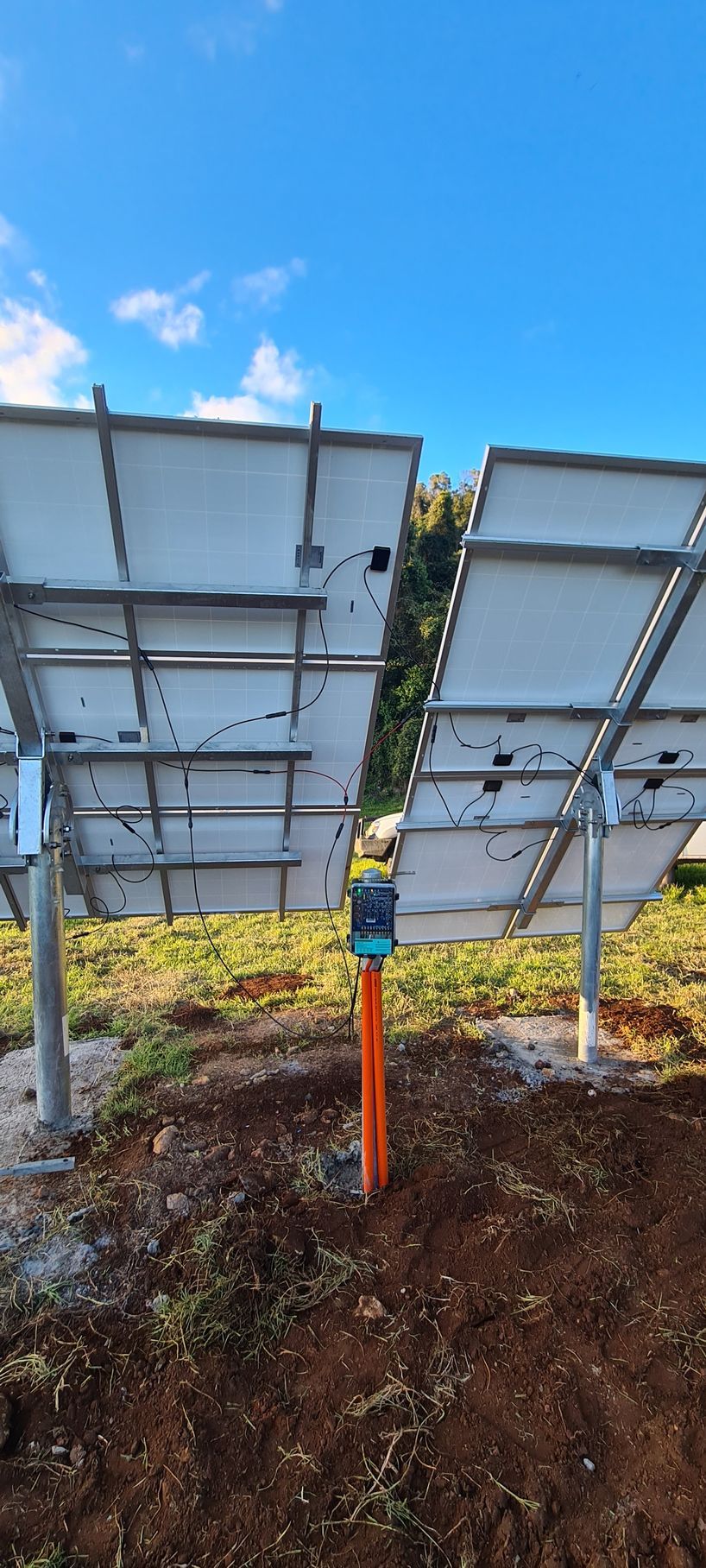 A Row Of Solar Panels Are Sitting In The Middle Of A Grassy Field — Midcoast Irrigation & Horticultural Supplies In Wauchope, NSW