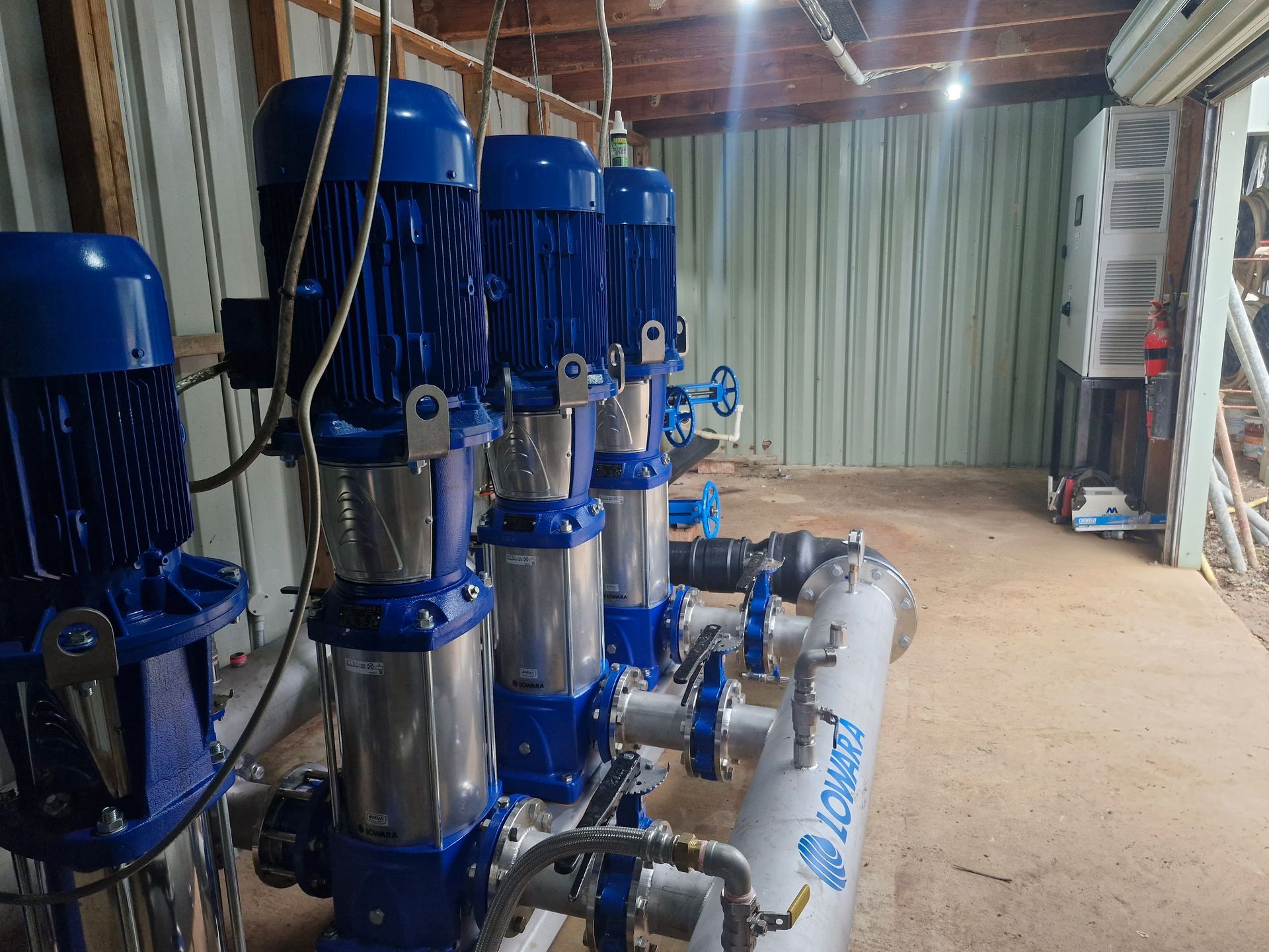 A row of blue and silver pumps are lined up in a room. — Midcoast Irrigation & Horticultural Supplies In Wauchope, NSW