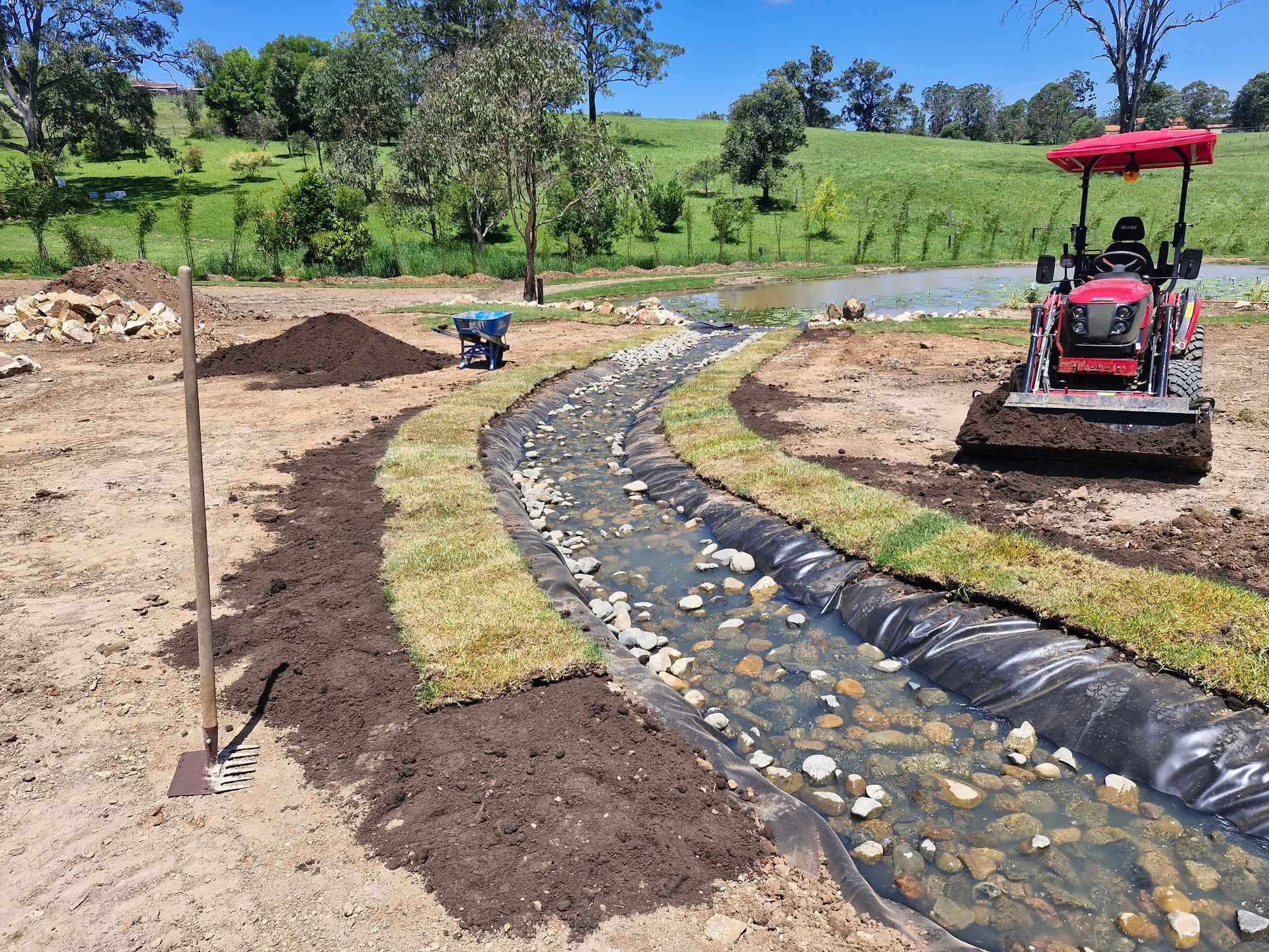 A Pipe is Pouring Water Into a Pond — Midcoast Irrigation & Horticultural Supplies In Wauchope, NSW
