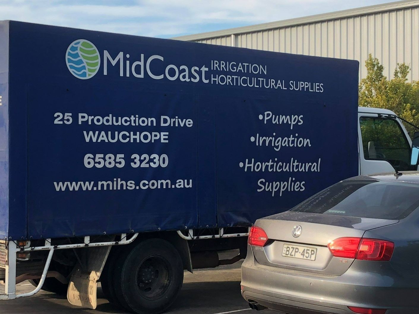 A Midcoast Irrigation Truck Is Parked Next To A Car — Midcoast Irrigation & Horticultural Supplies In Wauchope, NSW