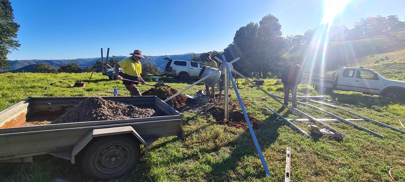 A Group of People Are Working in a Field With a Trailer — Midcoast Irrigation & Horticultural Supplies In Wauchope, NSW