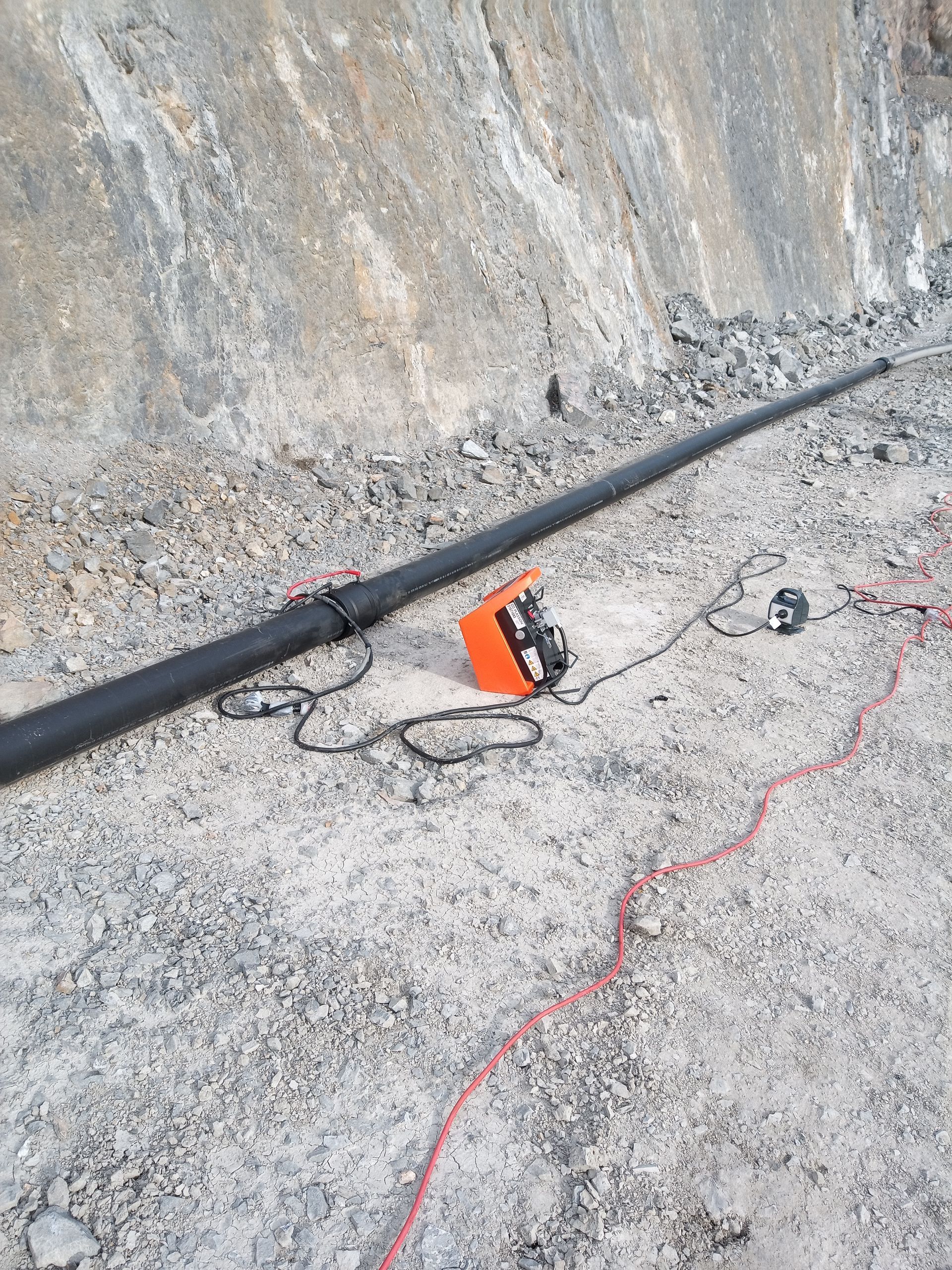 A fishing rod is laying on the ground next to a cord. — Midcoast Irrigation & Horticultural Supplies In Lake Cathie, NSW