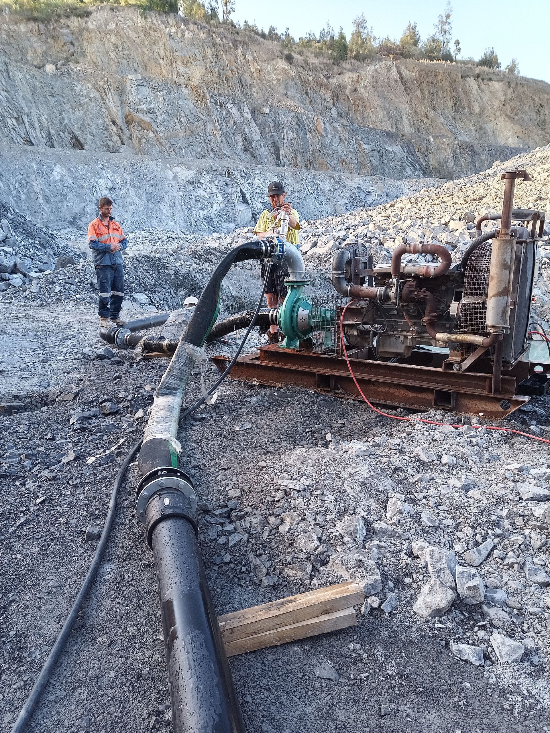 A Couple Of Men Operating A Large Machine In A Construction Site — Midcoast Irrigation & Horticultural Supplies In Wauchope, NSW