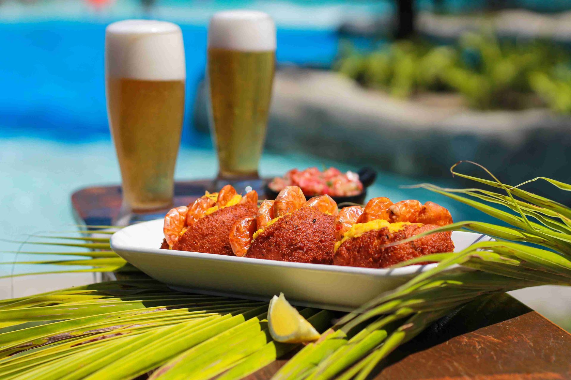 Porção de acarajé com camarão e copos de chopp gelado servidos na piscina do resort all inclusive Enotel Porto de Galinhas