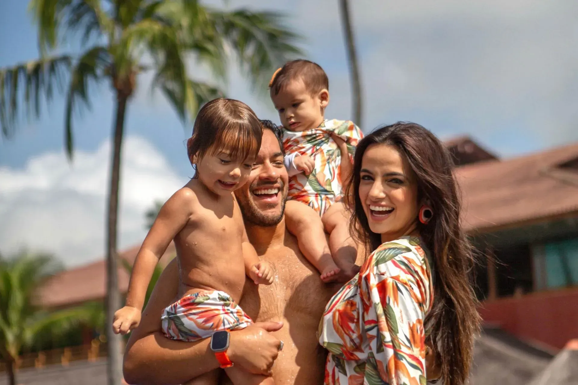 Família sorridente com dois filhos pequenos aproveitando as férias e momentos de lazer no resort all inclusive Enotel Porto de Galinhas