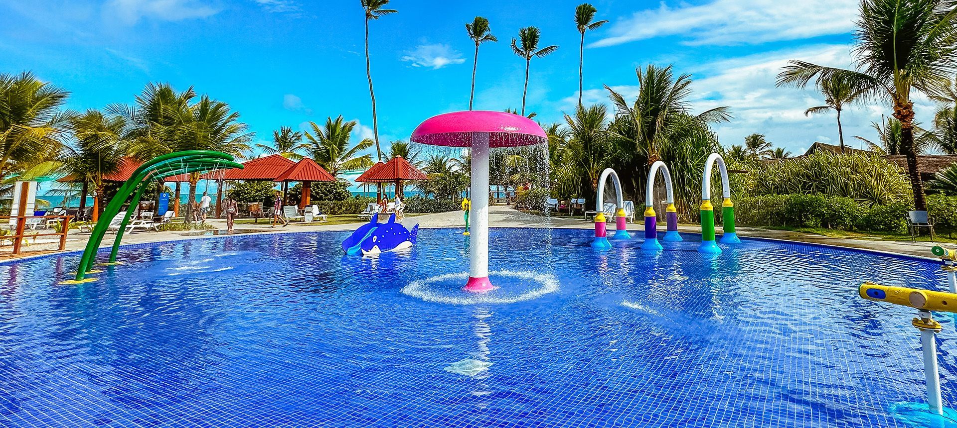 Parque aquático infantil do Enotel Porto de Galinhas com chafariz em formato de cogumelo rosa e brinquedos interativos na piscina
