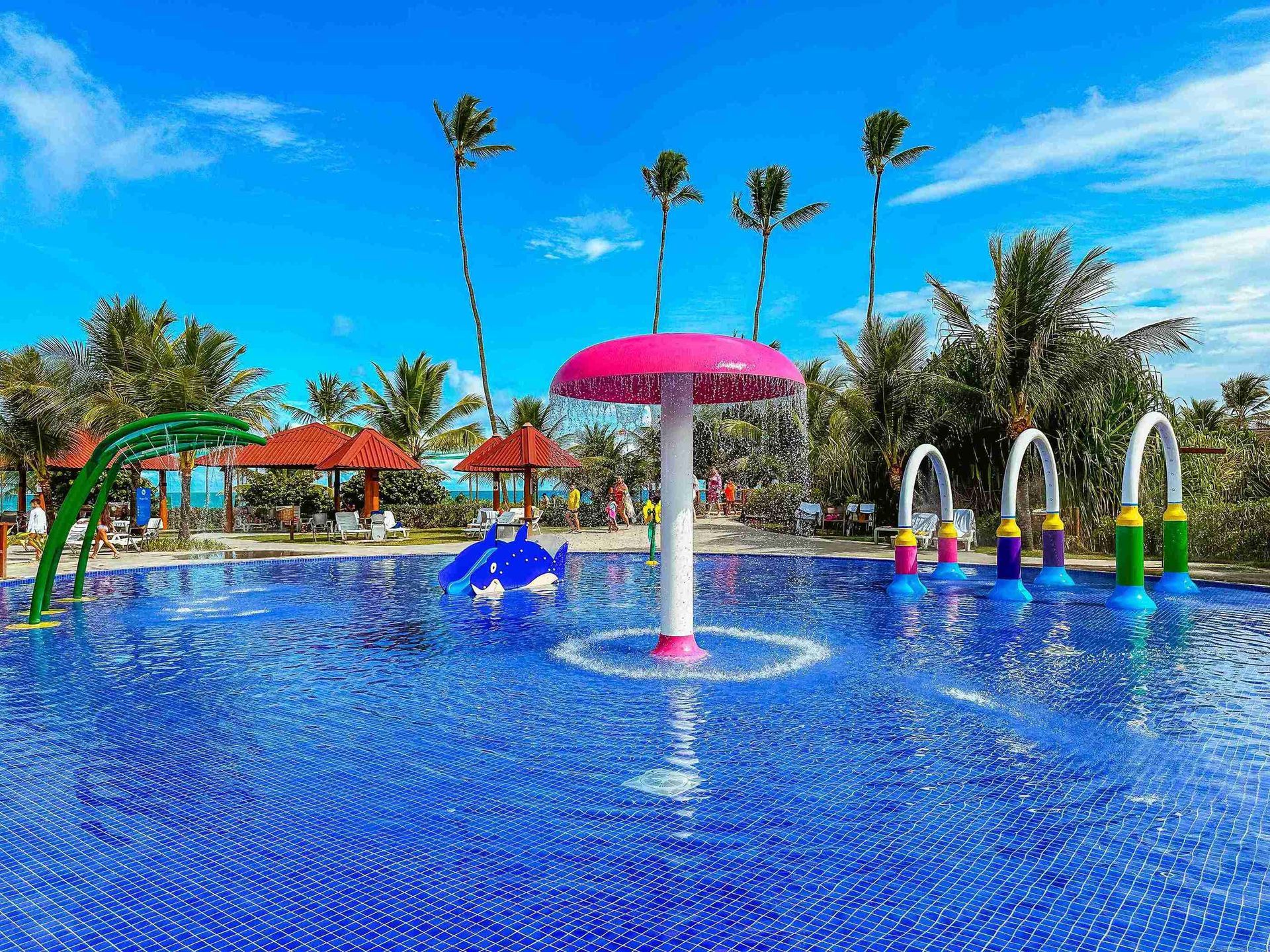 Piscina infantil do parque aquático com chafariz de cogumelo rosa e brinquedos aquáticos interativos no Enotel Porto de Galinhas