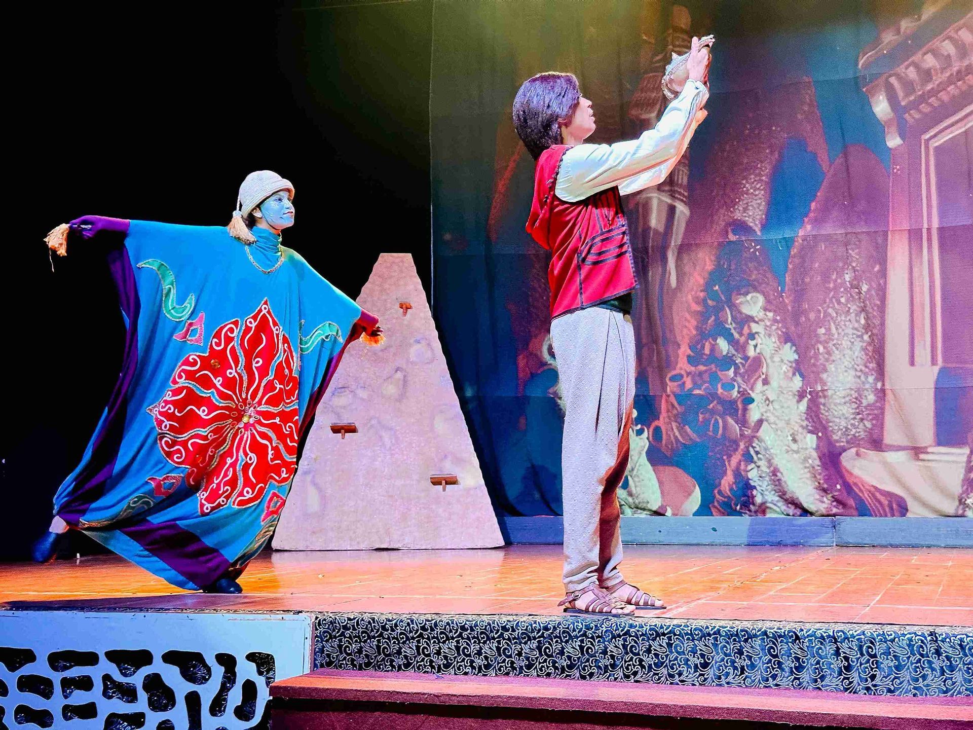 Apresentação de peça teatral com atores fantasiados no palco do teatro do Enotel Porto de Galinhas, destacando a programação noturna de lazer do resort.