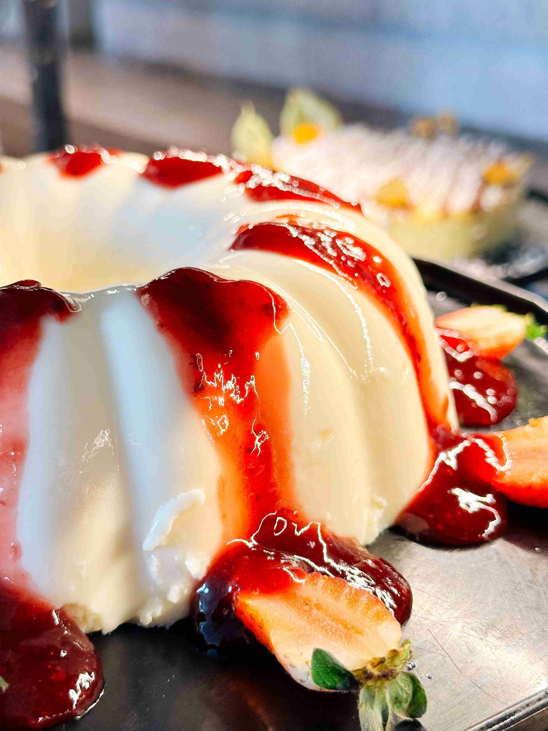 Pudim de leite com calda de morango e pedaços da fruta fresca servido no buffet de sobremesas do Enotel Porto de Galinhas
