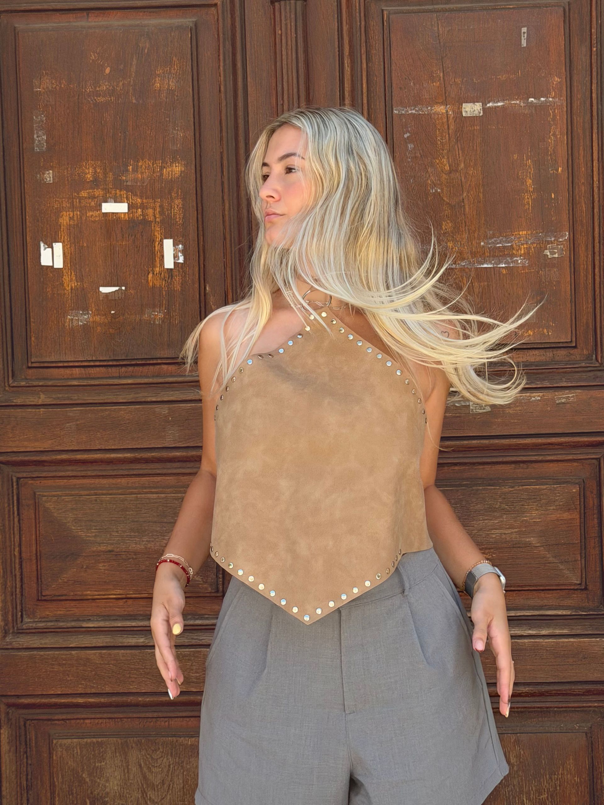 Una mujer con una camiseta color canela y pantalones cortos grises