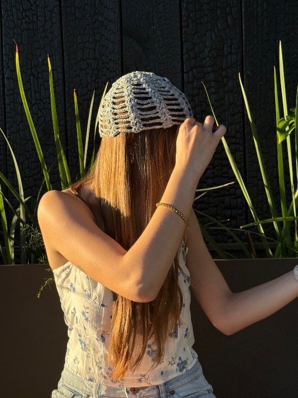 Una mujer con sombrero estampado y camiseta de tirantes con estampado