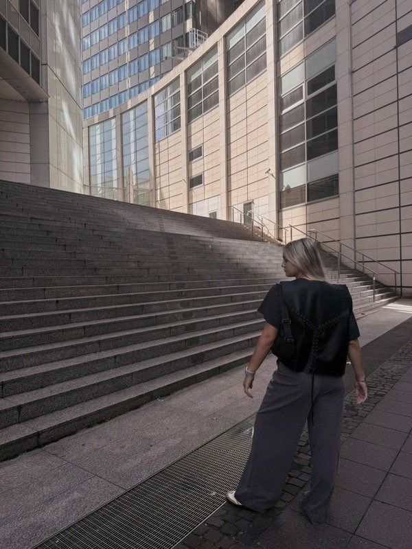 Una mujer vestida con pantalones grises y camisa negra