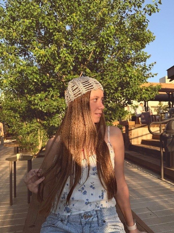 Una mujer con sombrero estampado y camiseta de tirantes con estampado