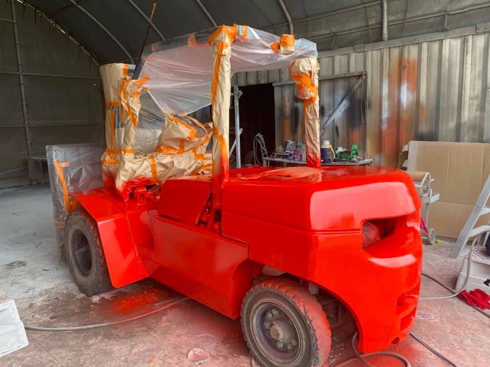 A Red Forklift is Being Painted in a Garage — All Blast and Paint in Paget, QLD