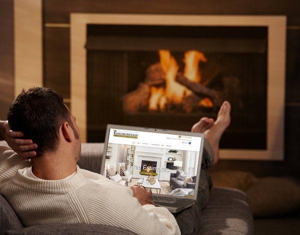 Man Browsing a Website in Front of the Fireplace — Cary, IL — Kingsborough Chimney Sweep Inc