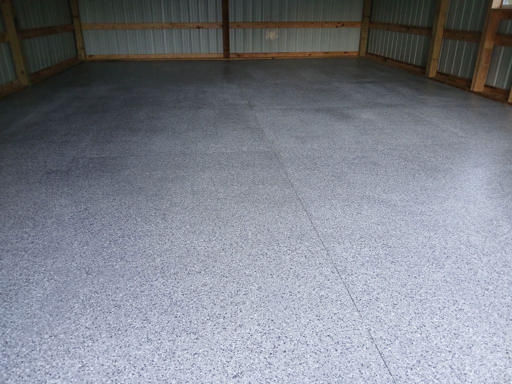 Gray epoxy-coated concrete floor inside a metal-sided building.