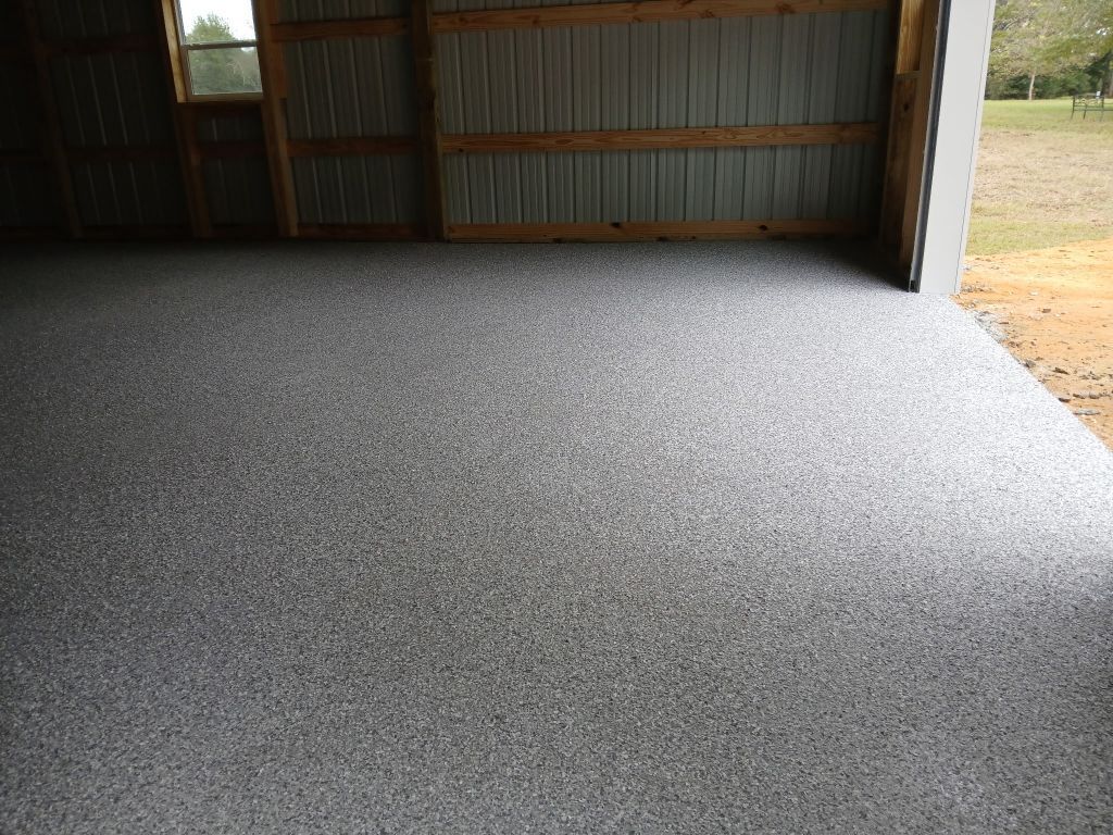 Color-stained concrete floor in green and orange tones. A white pillar and baseboard are on the side.
