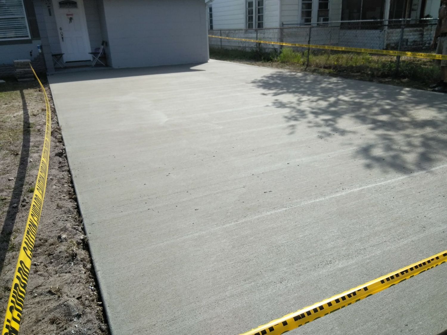 Newly poured concrete driveway with caution tape.