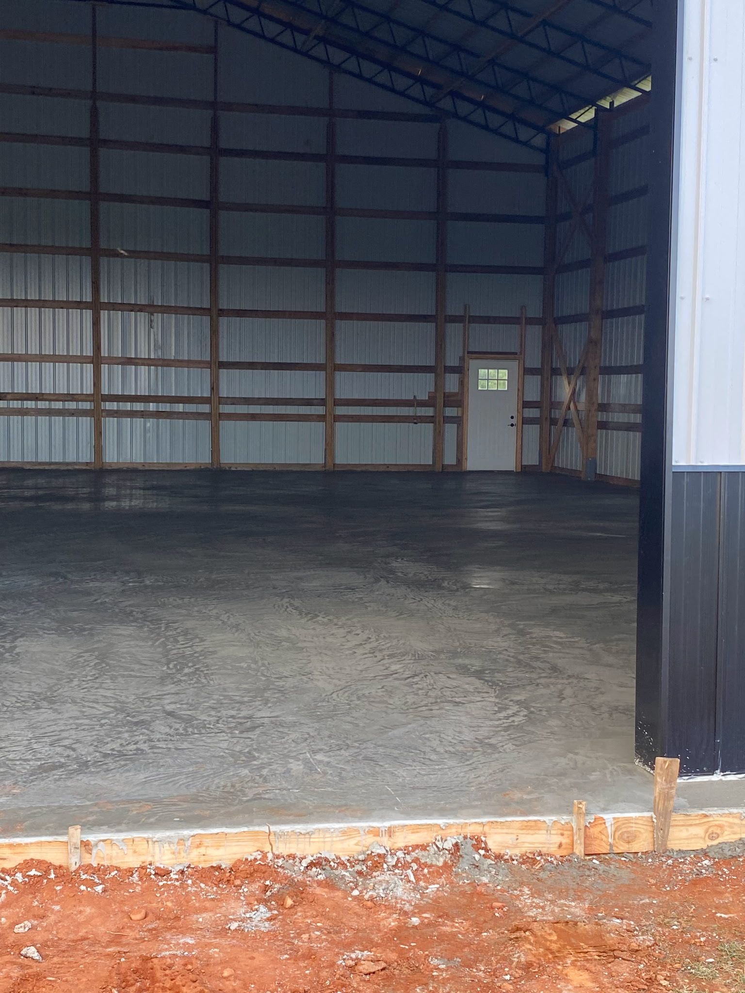 Concrete slab with wooden posts and beams under a blue sky, construction site.