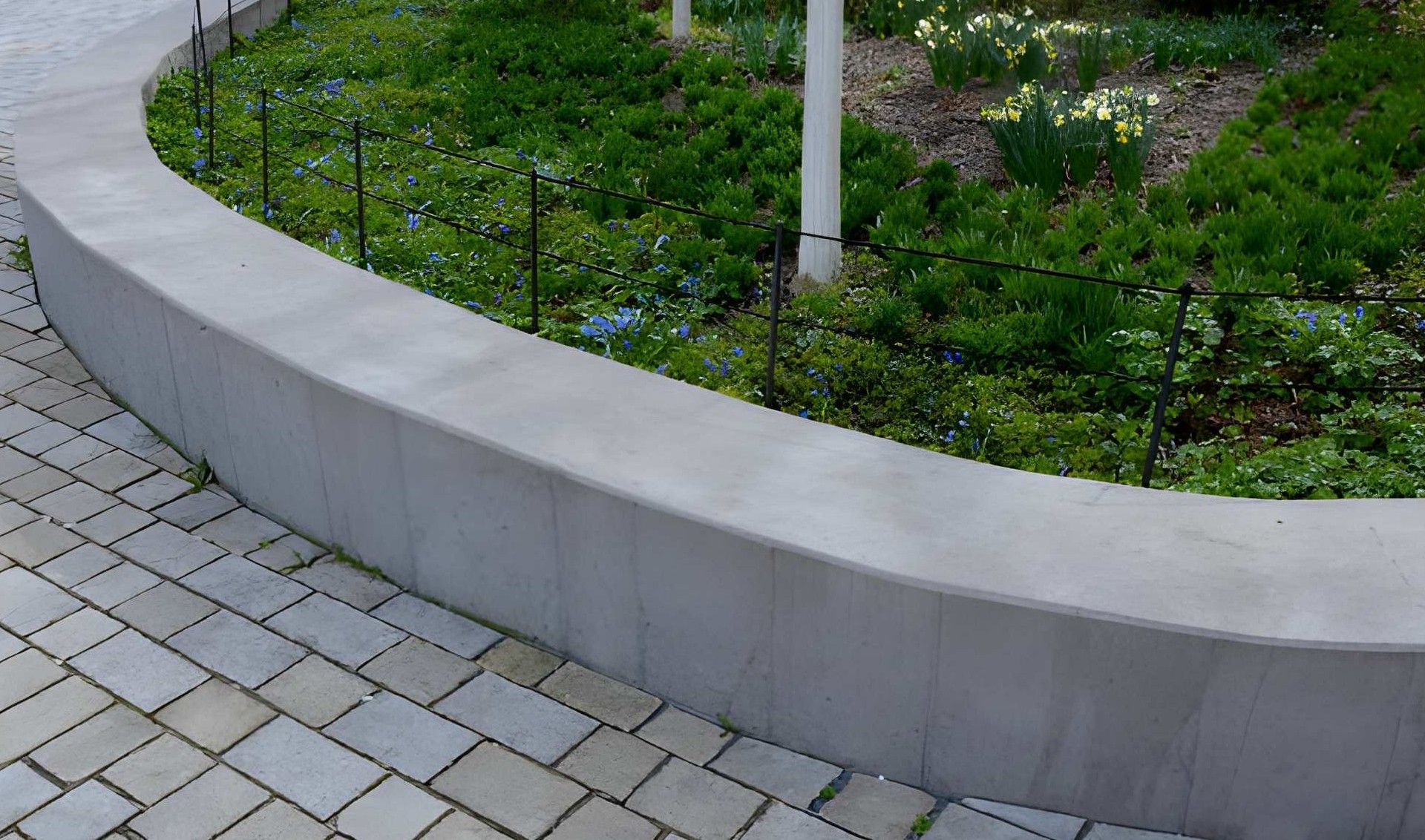 Concrete block retaining wall under construction on a hillside.