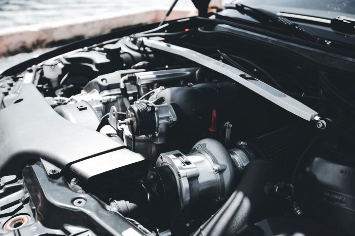 Un primer plano del motor de un automóvil con el capó abierto.