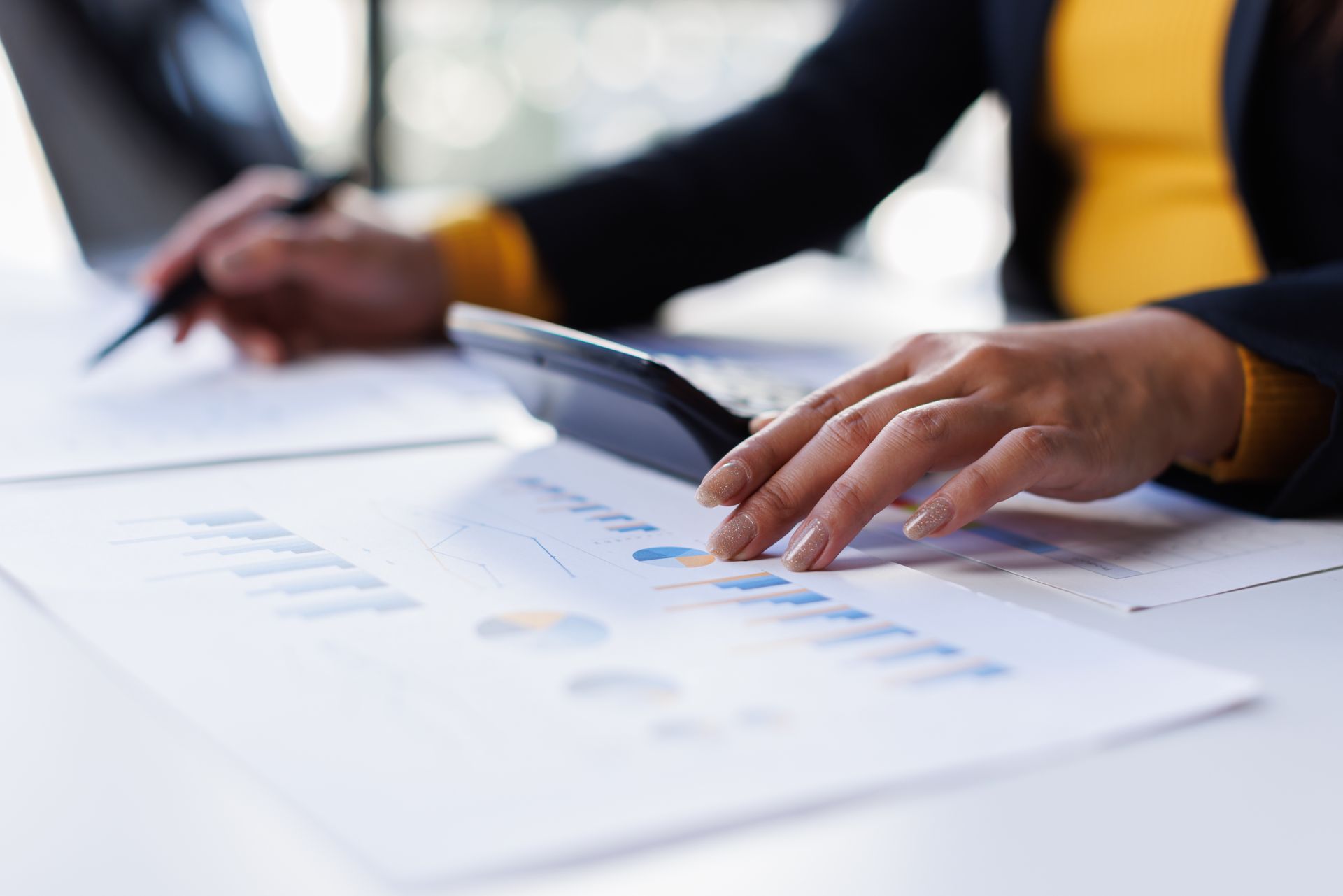 Hands reviewing a document with charts on a desk in an office setting