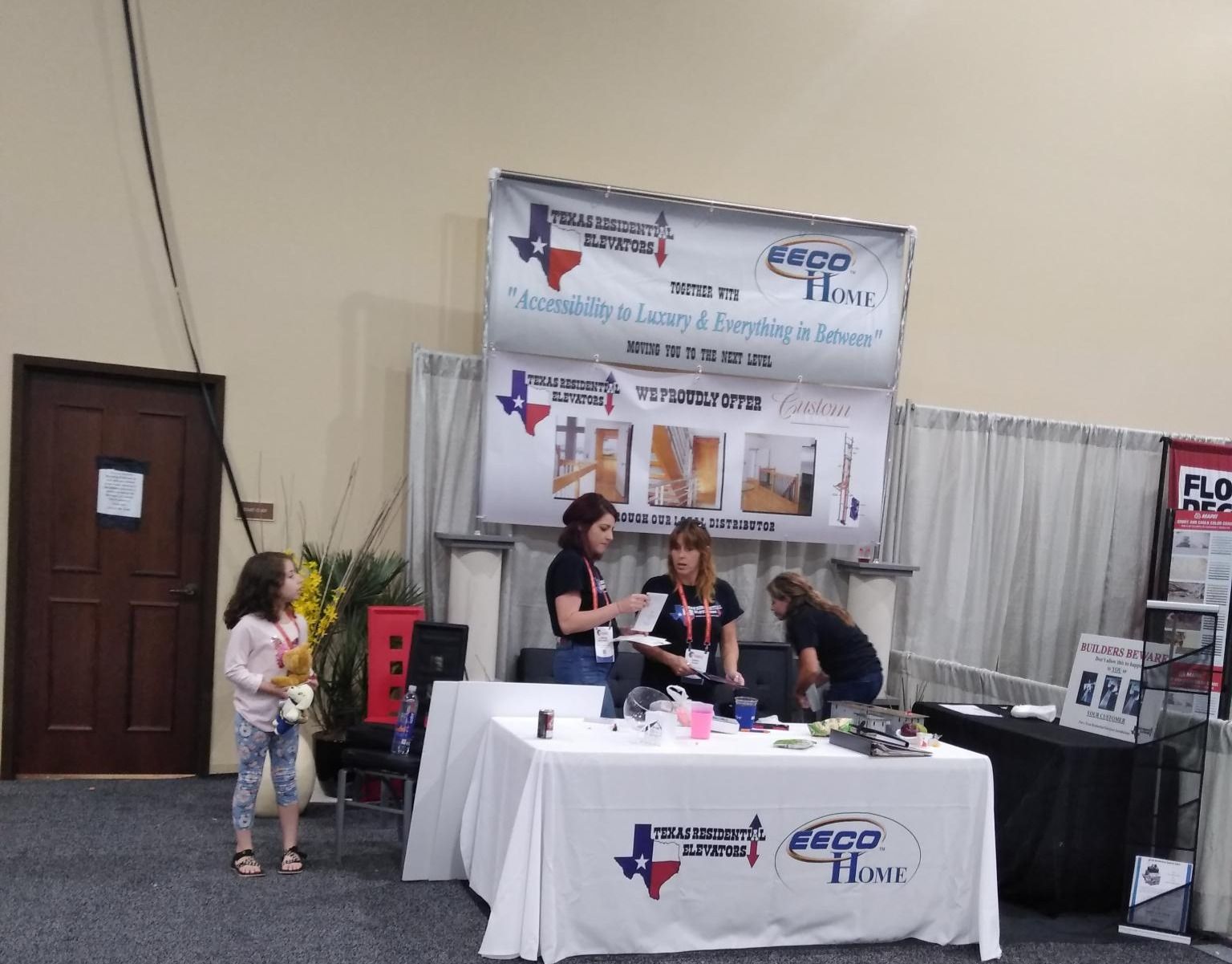 A Group of People Are Standing Around a Table at a Convention