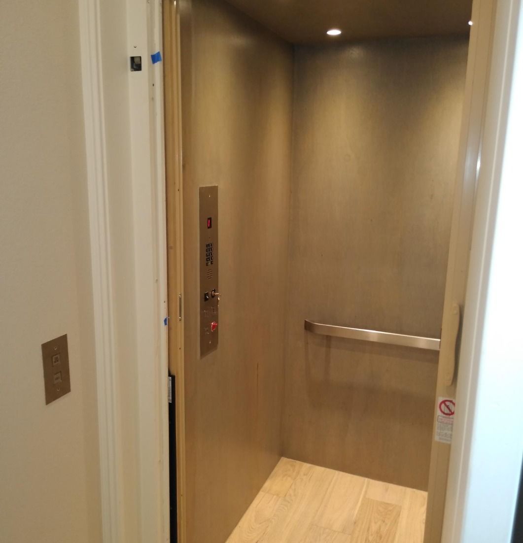 A Small Elevator With a Wooden Floor and a Door