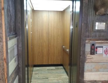 An Elevator With Wooden Walls and a Stainless Steel Door
