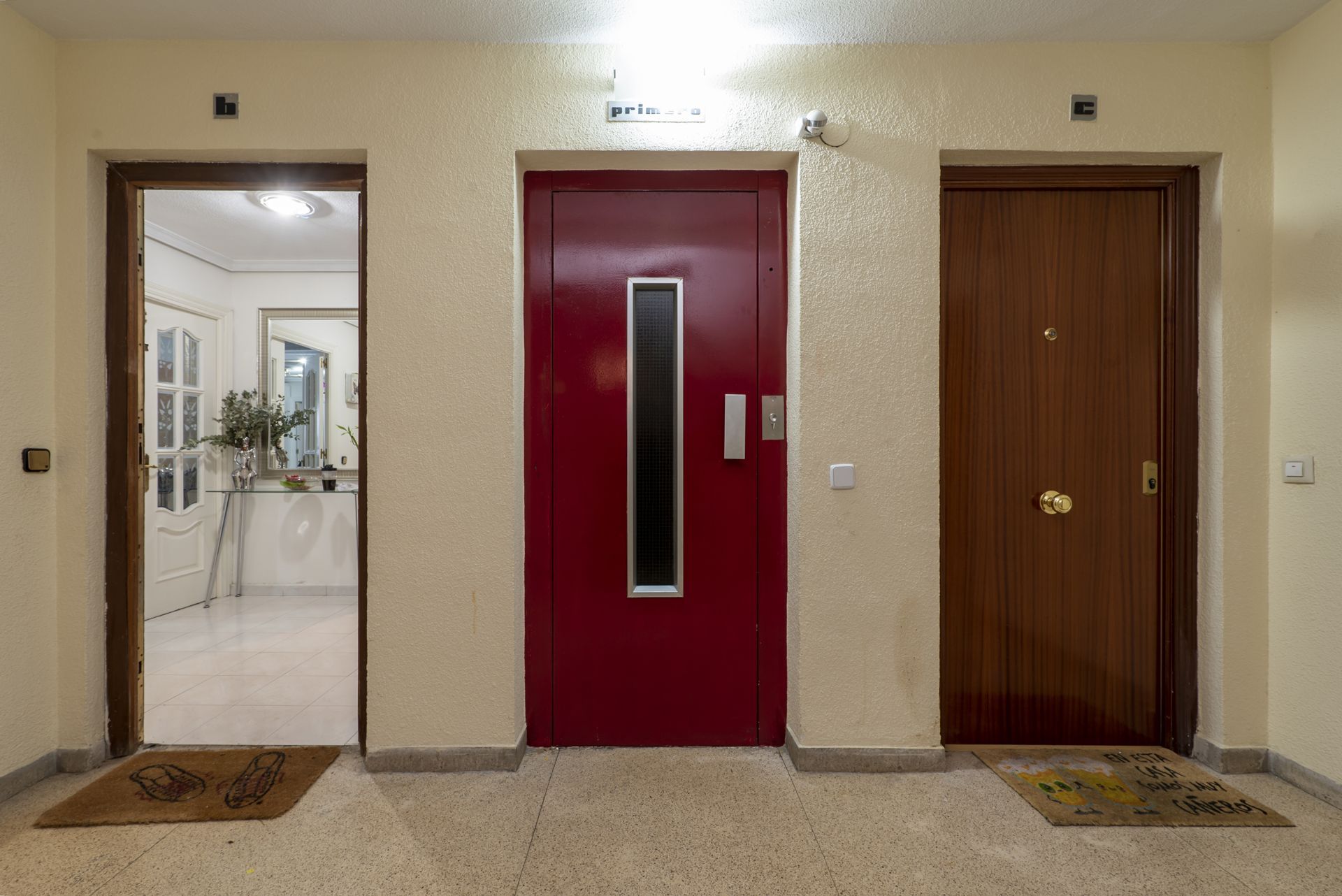 A Hallway With Two Red Doors and Two Brown Doors