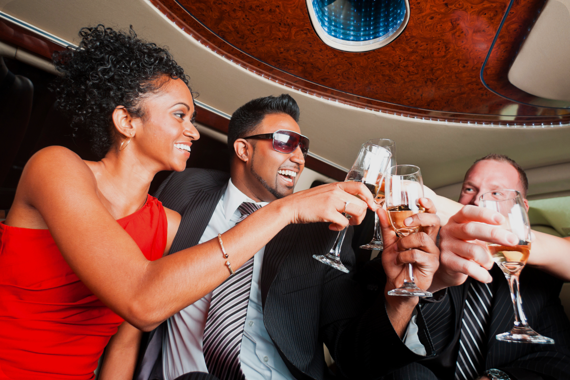 A group of people are toasting with champagne glasses riding in style with EVENTS.LIMO